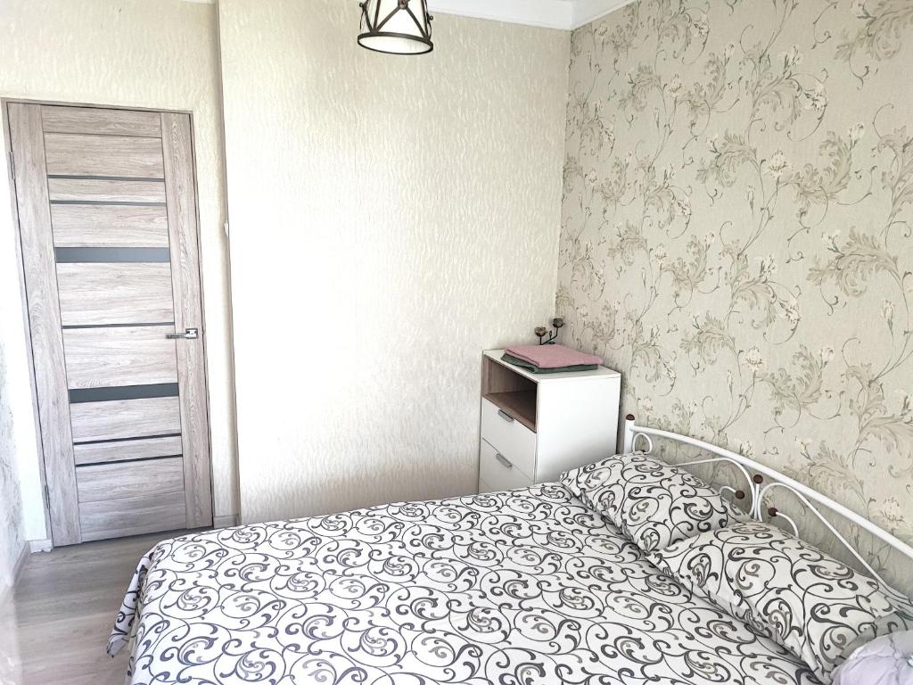 a small bedroom with a bed and a door at Автовокзал in Rivne