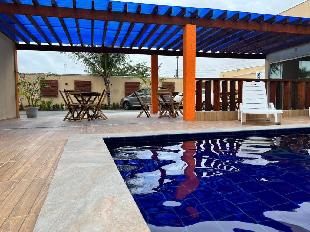 a swimming pool with a pergola and a table and chairs at Chalé Travosa in Santo Amaro