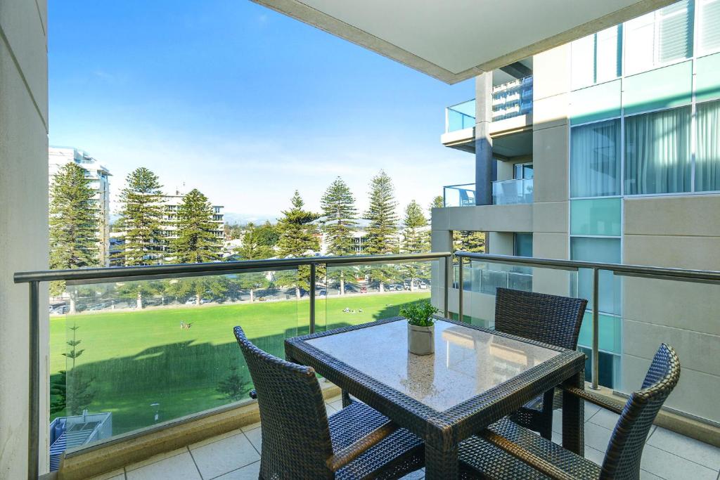 einen Balkon mit einem Tisch und Stühlen mit Aussicht in der Unterkunft Pier Apartment - Glenelg Views - No 506 in Adelaide