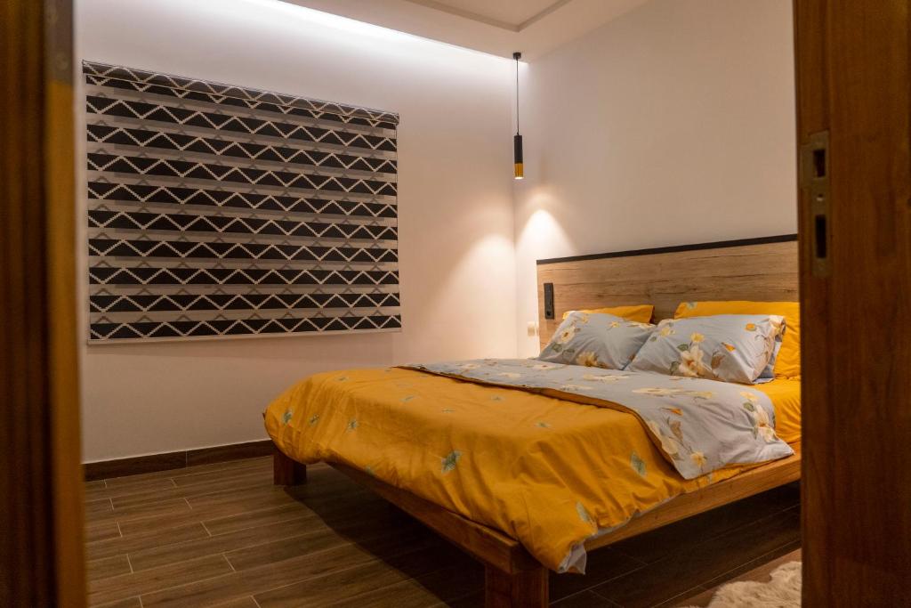 a bedroom with a bed with a yellow bedspread at Oasis Appart Benin in Cotonou
