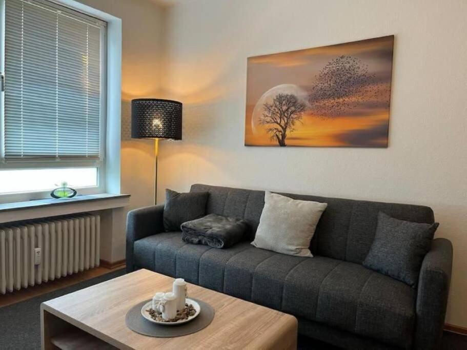 ein Wohnzimmer mit einem Sofa und einem Tisch in der Unterkunft Ferienappartement am Meer in Wilhelmshaven