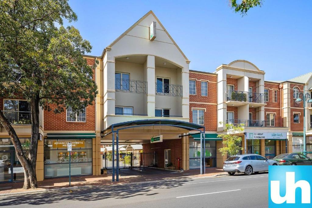 un edificio en una calle con un coche aparcado delante en The Grand Apartments North Adelaide Parking, en Adelaida