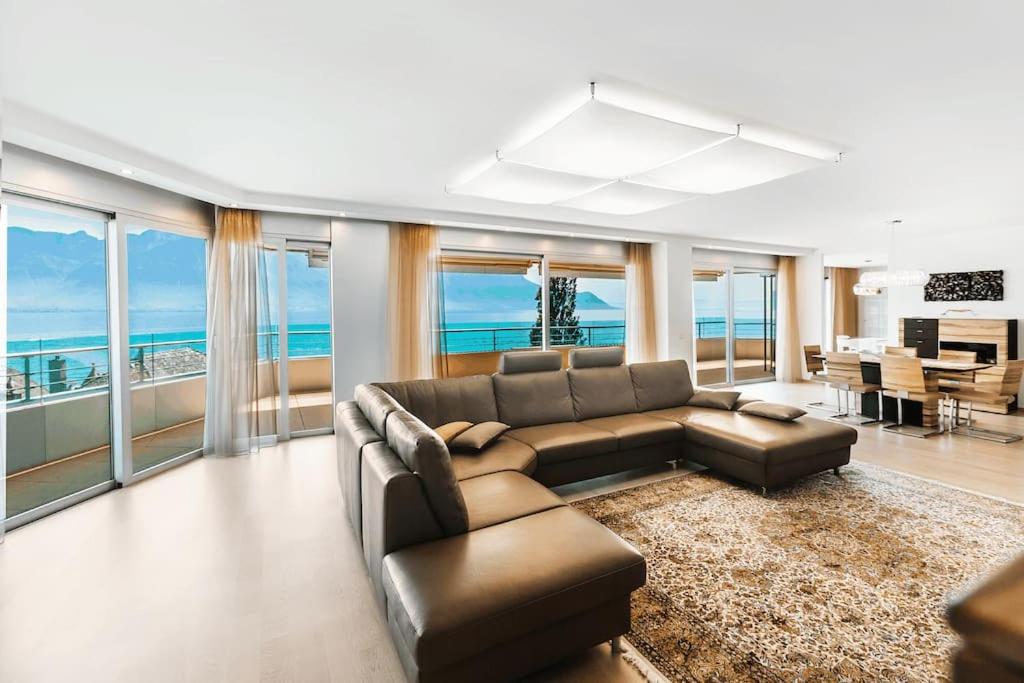 uma grande sala de estar com um sofá e uma mesa em Montreux Lake View Apartment 4 Bedrooms em Montreux