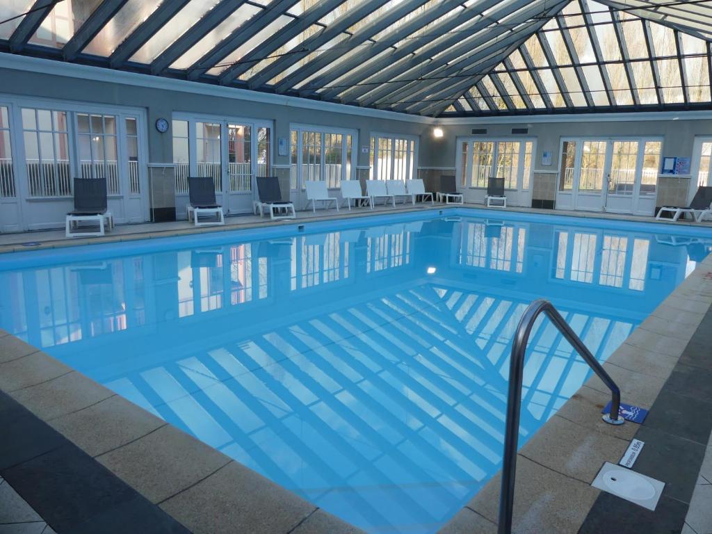 une grande piscine dans un immeuble dans l'établissement Appart 4 pers av balcon-parking gratuit-piscine int chauffée-serviettes et linge de lit compris, à Le Touquet-Paris-Plage