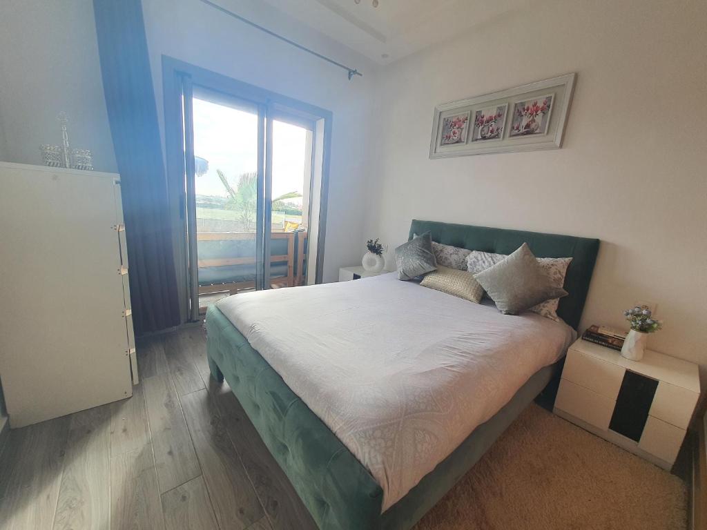 1 dormitorio con cama y ventana grande en HEAVEN BEACH en Sidi Rahal
