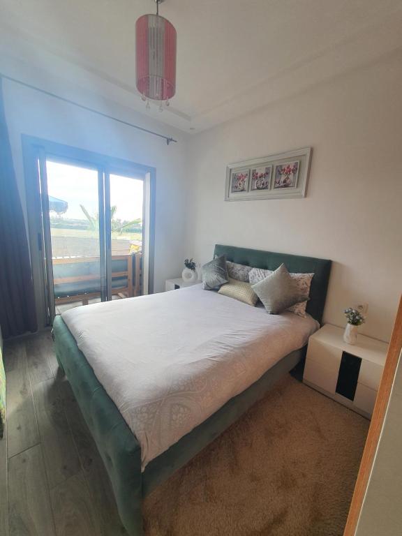 a bedroom with a large bed and a window at HEAVEN BEACH in Sidi Rahal