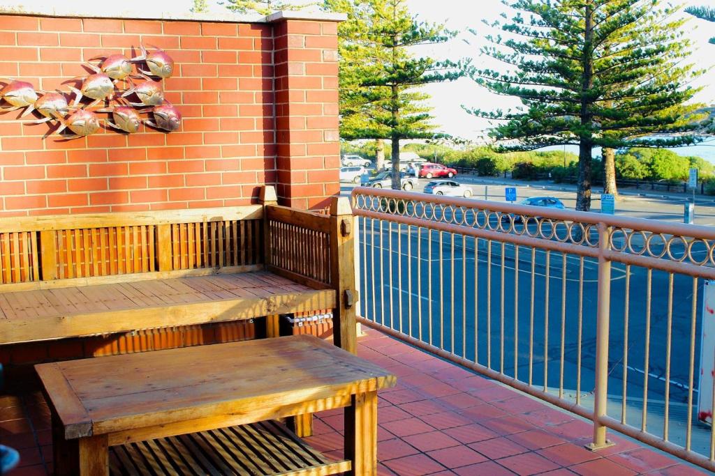 a wooden bench sitting on the side of a building at Vista Victor Harbor Beachfront Apartment No 4 in Victor Harbor