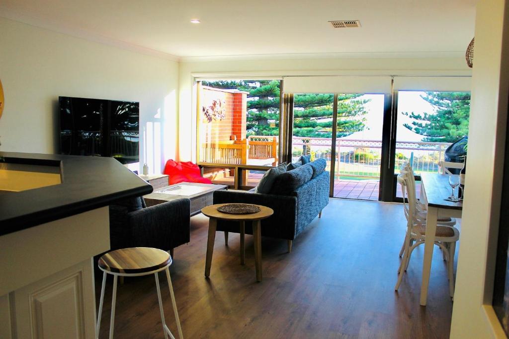 ビクターハーバーにあるVista Victor Harbor Beachfront Apartment No 4のソファとテーブルのあるキッチンとリビングルーム