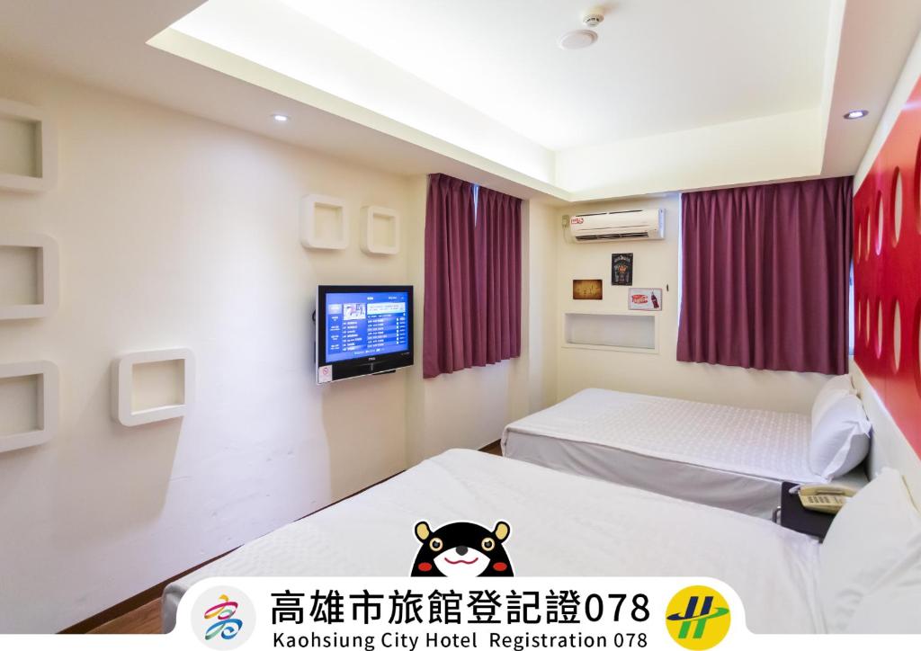 um quarto de hospital com duas camas e uma televisão em Newrise Hotel em Kaohsiung