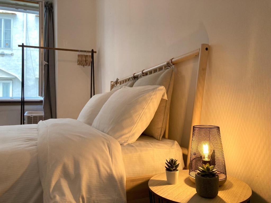 um quarto com uma cama e uma mesa com um candeeiro em No Name - Via dell'Istria 12 em Trieste