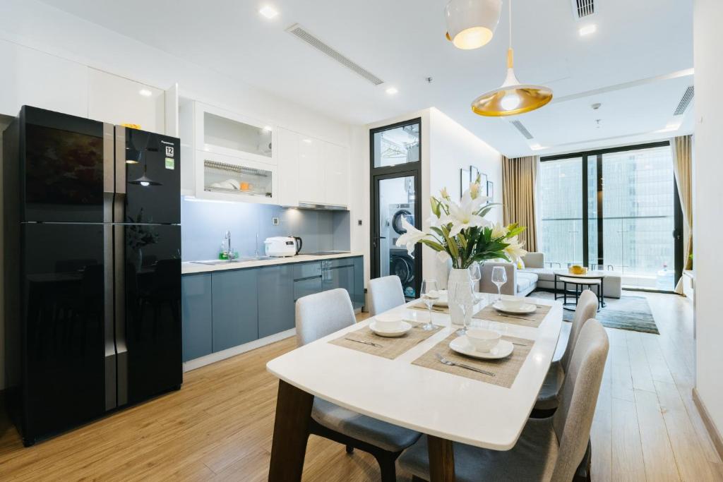 eine Küche und ein Esszimmer mit einem weißen Tisch und Stühlen in der Unterkunft Lynn Housing- Vinhomes Metropolis- LUX. Apartment system in Hanoi