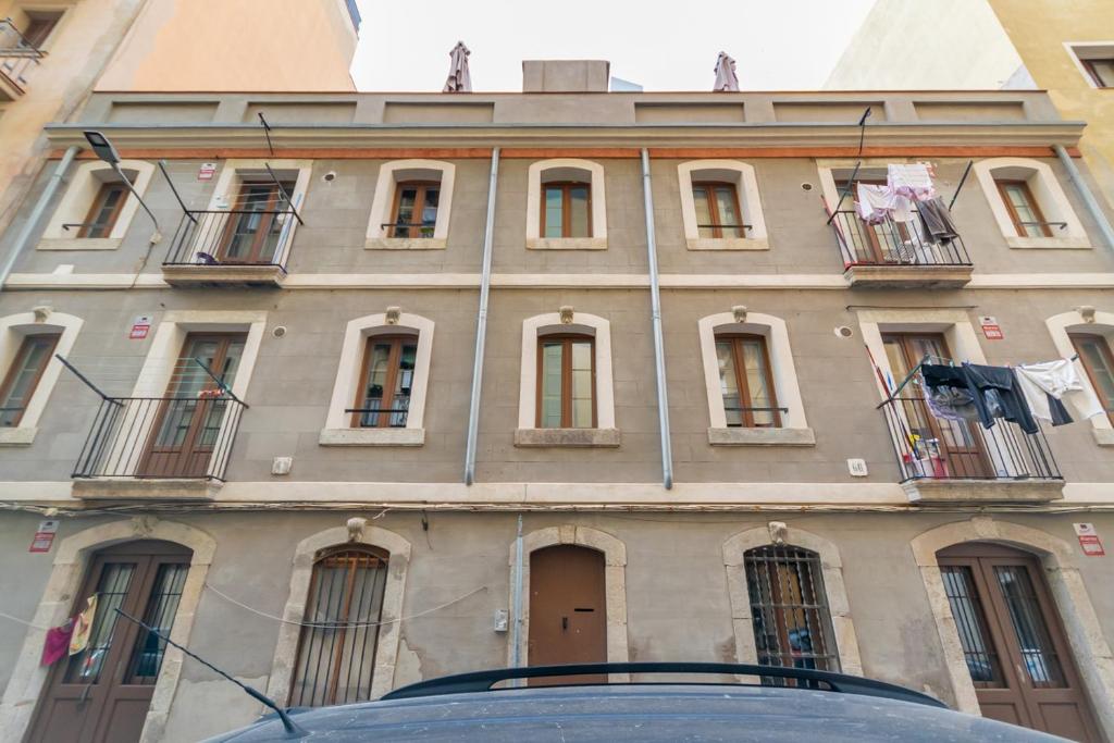 Un edificio con ventanas y un coche delante. en Apartment Pontevedra 20m from the beach, en Barcelona