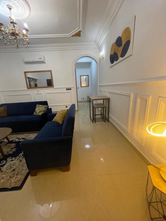 una sala de estar con 2 sofás azules y una mesa. en Tarablue appart, En plein centre-ville, Agréable & spacieux, en Libreville