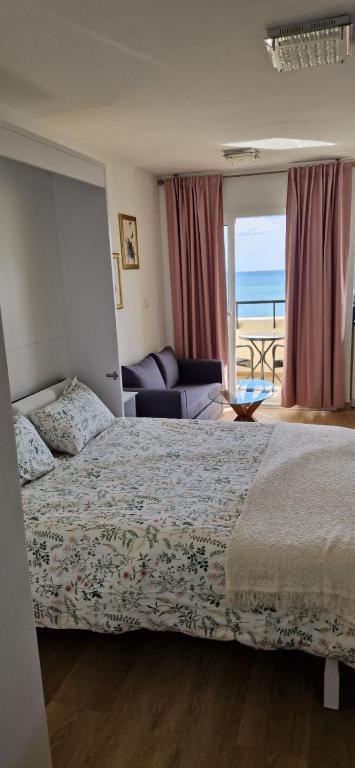 a bedroom with a bed and a view of the ocean at Luxury Studio Costa del Sol in Torremolinos