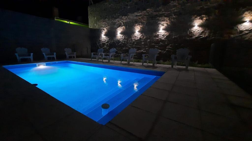 ein Schwimmbad in der Nacht mit Leuten um ihn herum in der Unterkunft Las Tranqueritas in Trapiche