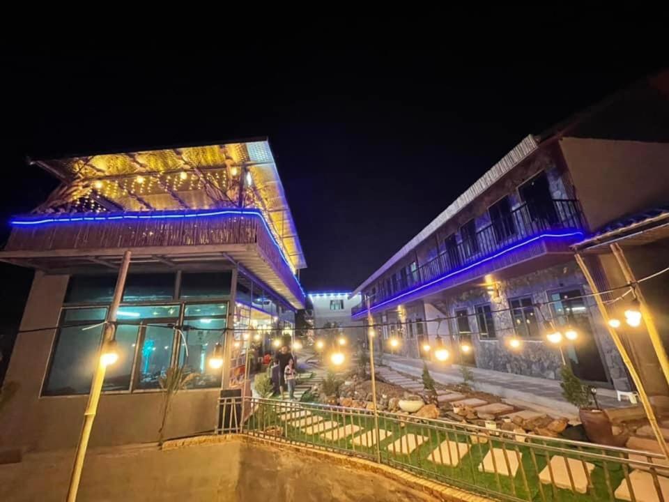 um edifício com luzes azuis à noite em mộc châu homestay em Làng Môn