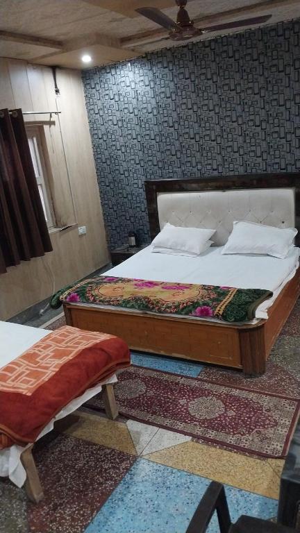 a bedroom with a large bed and a bed sidx sidx sidx at Somnath Dham in Vrindāvan