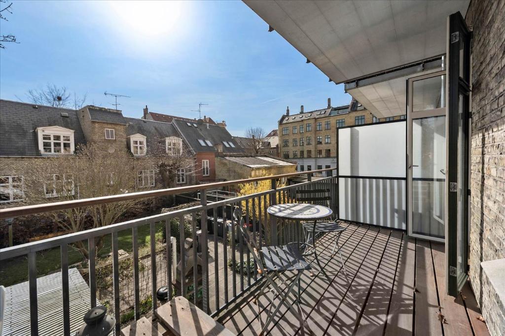 un balcón con mesa y sillas. en Full apartment 4min from the City Center, en Copenhague