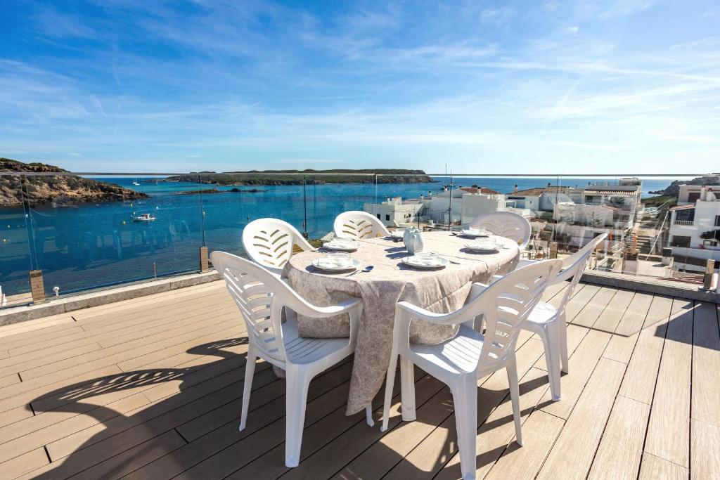 een tafel en stoelen op een balkon met uitzicht op de oceaan bij Preciosas vistas en Es Grau in Es Grau