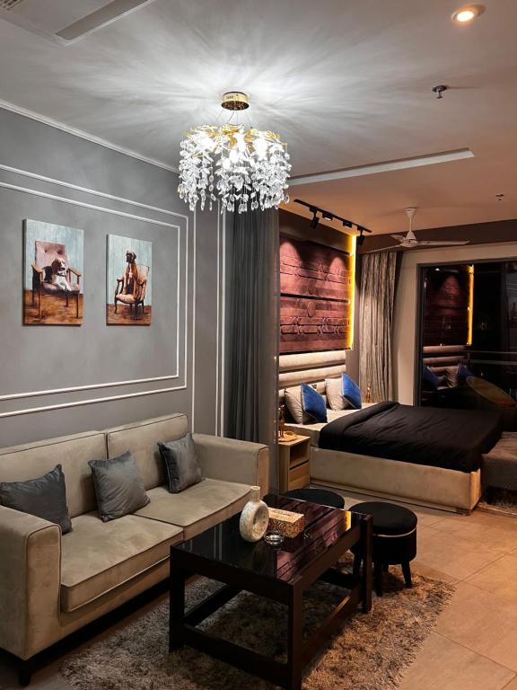 uma sala de estar com um sofá e um lustre em The Mauve by Velvet 38th Floor em Nova Deli