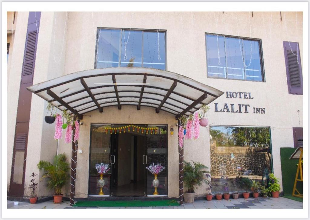 a hotel entrance with flowers in front of a building at Hotel Lalit inn By Royalstay in Lonavala