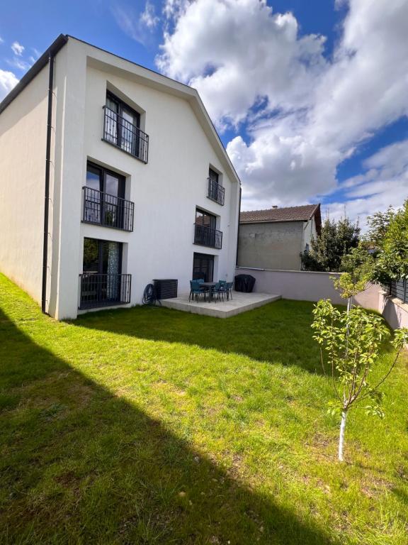a white house with a green lawn in front of it at Maison Villa in Vitry-sur-Seine