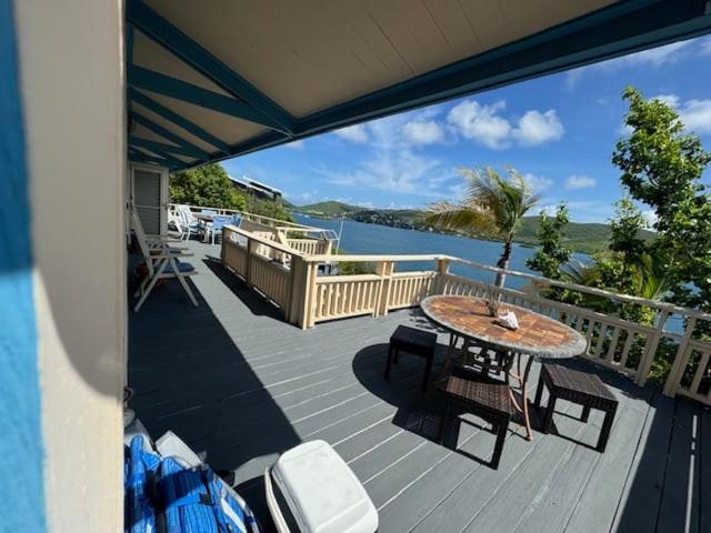 a deck with a table and chairs and a view of the water at Emma by the Bay in Culebra
