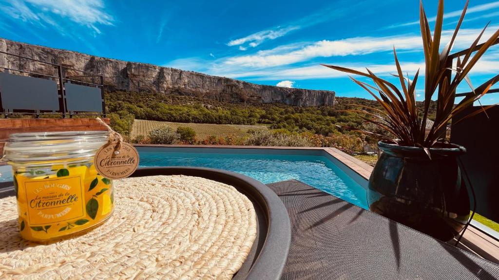 un pot de miel posé sur une table à côté d'une piscine dans l'établissement Gite La Madeleine du Luberon., à Lioux