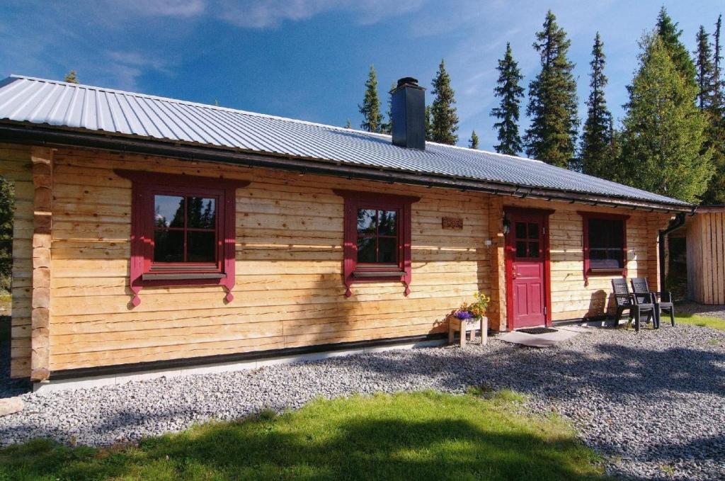 a log cabin with red doors and windows at Gemütliches neu erbautes Blockhaus auf Berghof mit Sauna und Kamin in Galåbodarna