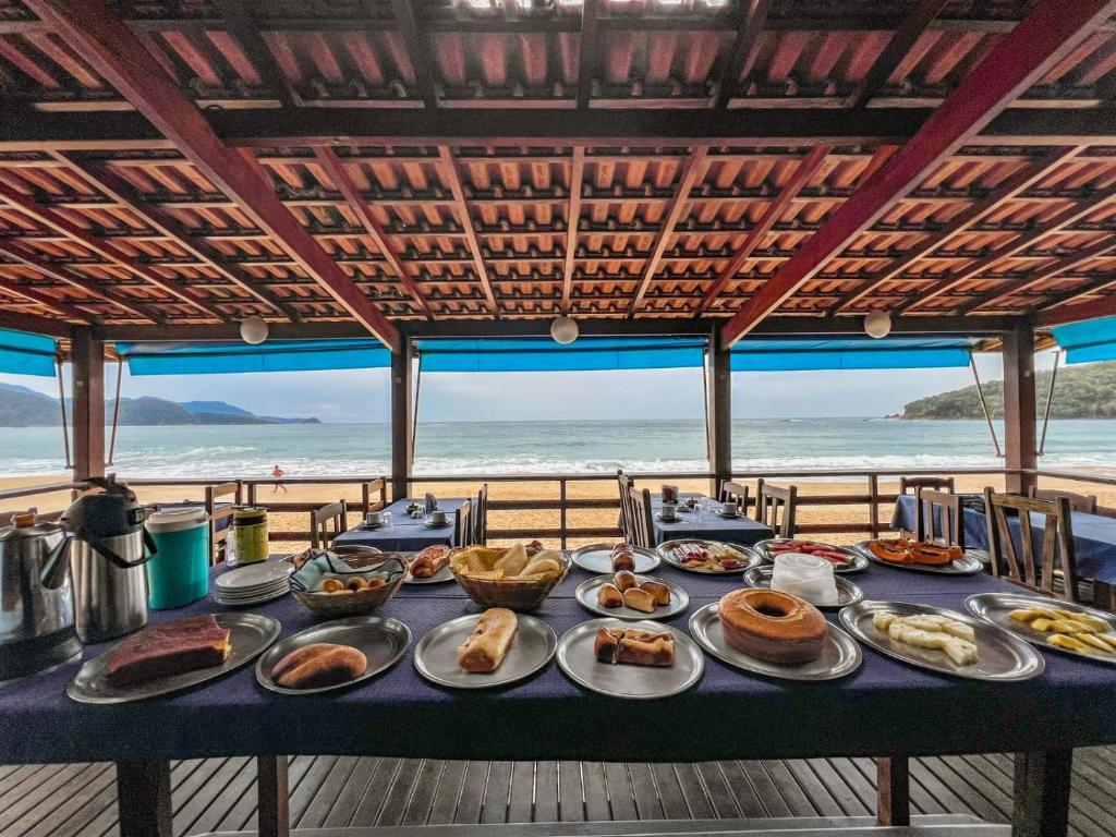 a table of food with a view of the beach at Hotel Garni Cruzeiro do Sul in Paraty