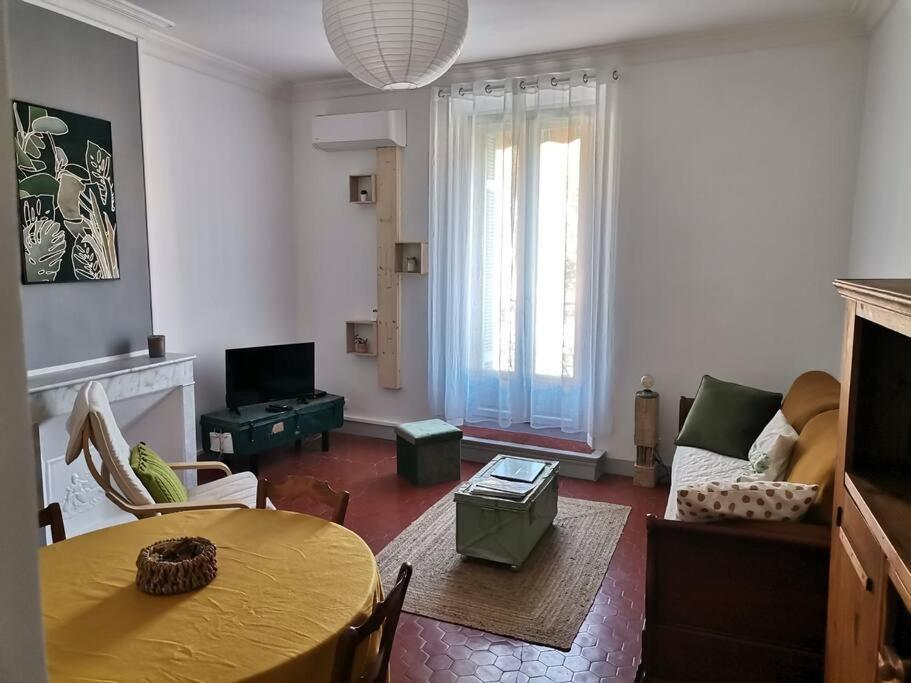 - un salon avec une table jaune et un canapé dans l'établissement Appartement cozy au cœur du village, à Roquebrune-sur Argens