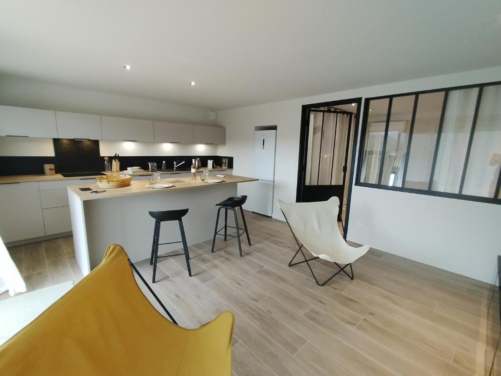 een keuken met een aanrecht en stoelen in een kamer bij T2 neuf, 1 chambre, golf Valcros in La Londe-les-Maures