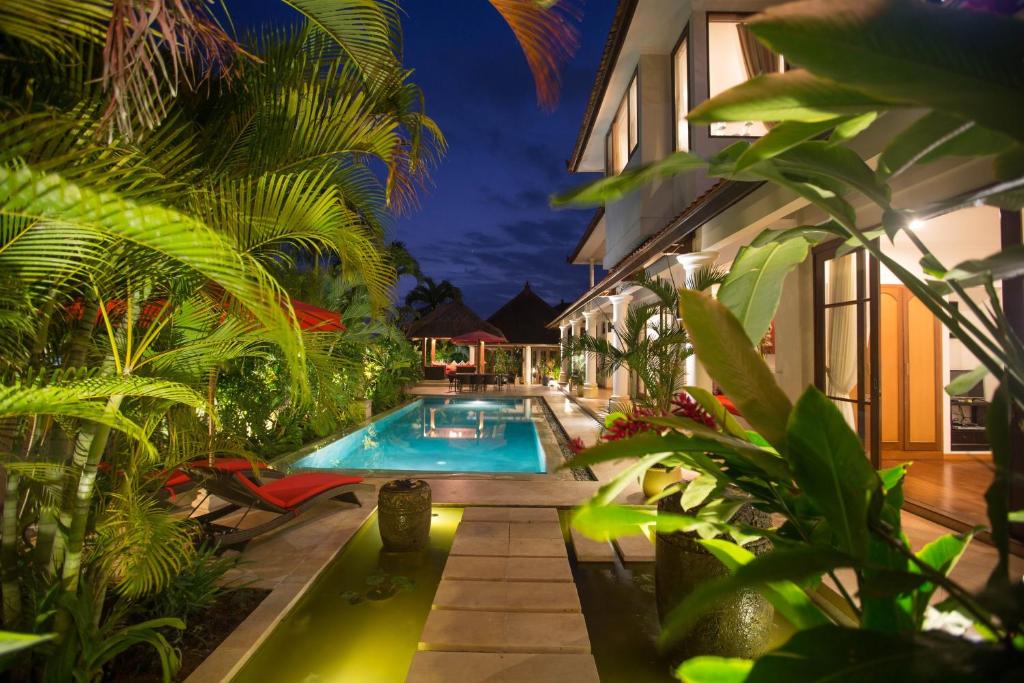 una piscina en medio de una casa con plantas en Villa Padi, en Canggu