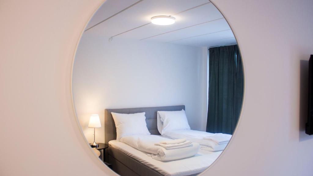 A Hotels Apartments Høje Taastrup في تائستروب: مرآة في غرفة مع سرير وأريكة