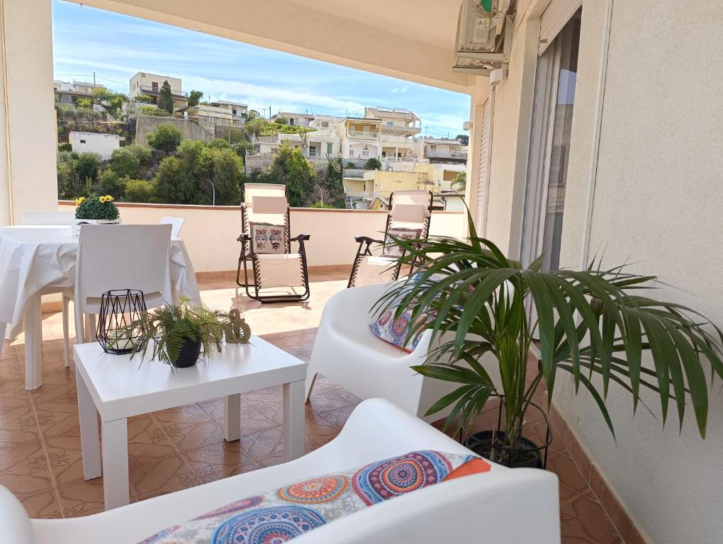 einen Balkon mit weißen Möbeln sowie einem Tisch und Stühlen in der Unterkunft Limoncello Home con Veranda vista Mare a 3 Min dalla spiaggia in Alcamo