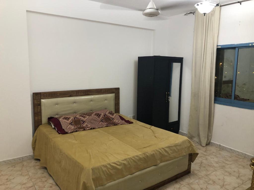 1 dormitorio con 1 cama en una habitación con ventana en Al Majaz King Size Room en Sharjah