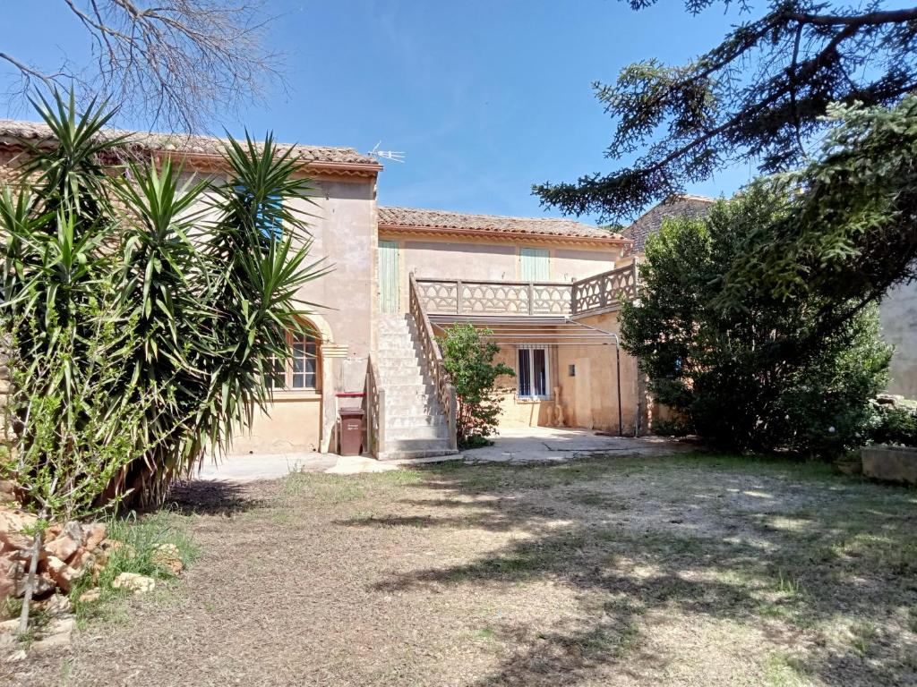 una casa con una palmera delante en A Cèdre de mon enfance, en Vers Pont du Gard