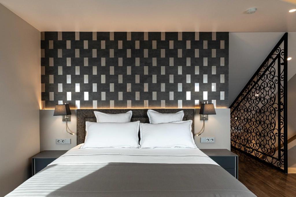 een slaapkamer met een groot bed met witte kussens bij AB BOUTIQUE HOTEL - Adults only in Sant Vicenç de Montalt