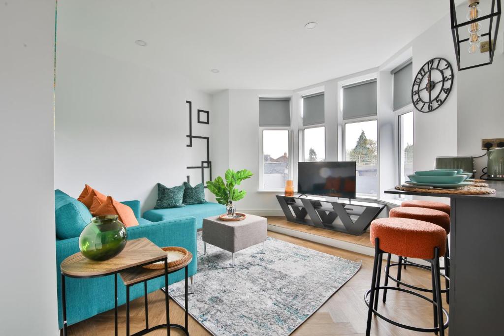 uma sala de estar com um sofá azul e uma televisão em North Road Luxe New Serviced Apartments- Parking Available with Full Kitchen Amenities em Cardiff