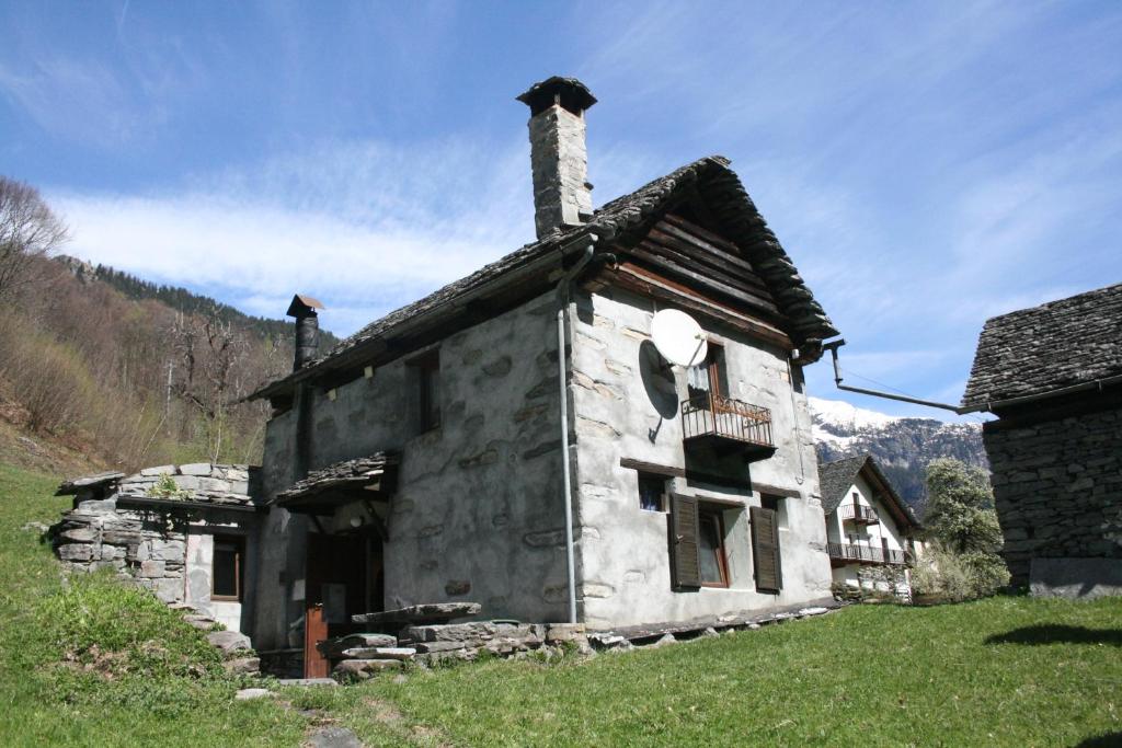 an old stone house with a chimney on a field at Rustico Rosso di Ribia 