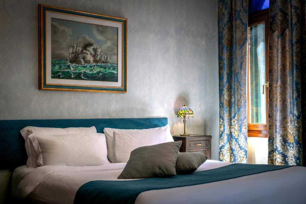 a bedroom with a bed and a painting on the wall at Palazzo San Luca in Venice