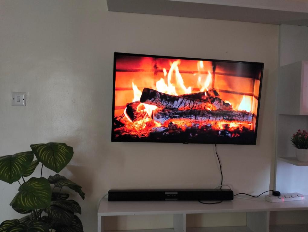 a flat screen tv hanging on a wall with a fireplace at Yalacosy homes in Kitengela 