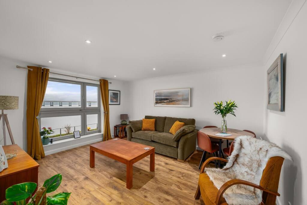 a living room with a couch and a table at Marine parade apartment with river view in Dundee