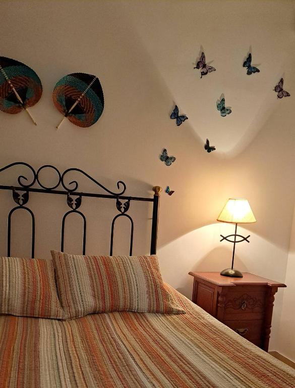 Casa Blue في توروكس: غرفة نوم مع سرير مع فراشات على الحائط