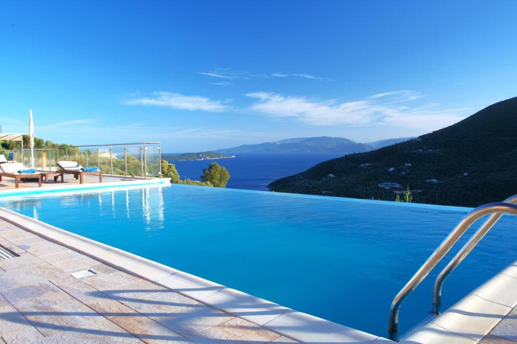 a large swimming pool with a view of the ocean at Adamas Villa in Sivota