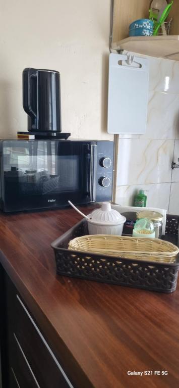 a kitchen counter with a microwave and a basket on it at Crystal Cribs Eldoret in Eldoret