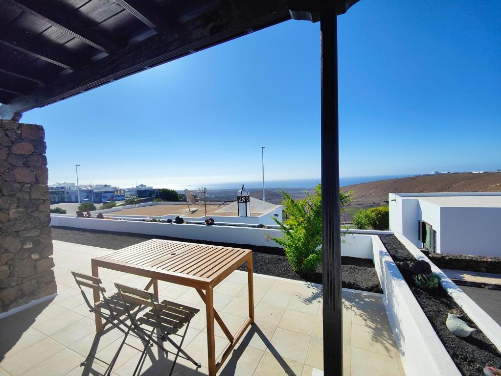 Una mesa y sillas en un balcón con vista al mar. en Casa María, en Tías