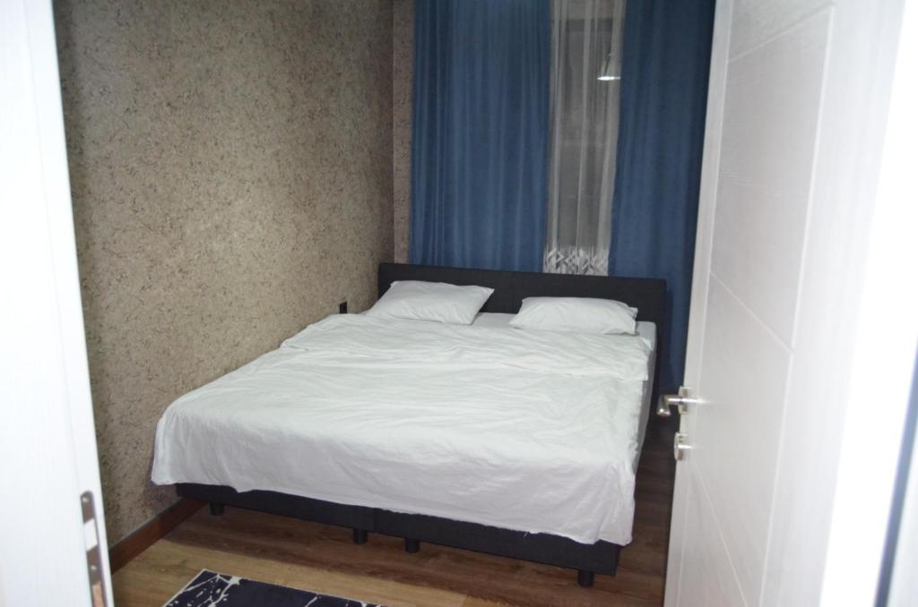 a bed with white sheets and pillows in a bedroom at BENİM EV in Akçatepe