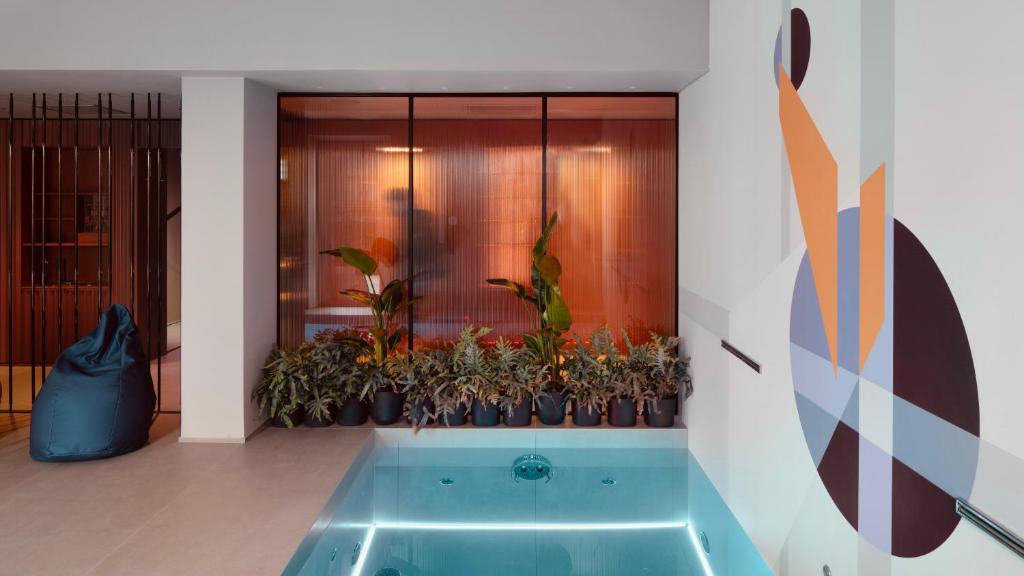 een badkamer met een bad met potplanten bij Interno Marche Design Experience Hotel in Tolentino