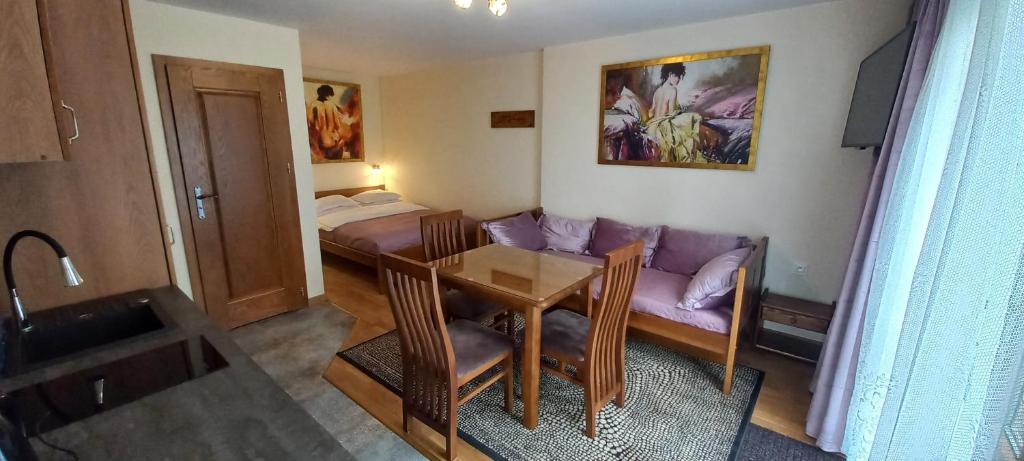 a living room with a couch and a table at APARTAMENTY i POKOJE - DOM GOŚCINNY PASJA -2 MINUTY DO PLAŻY in Dźwirzyno